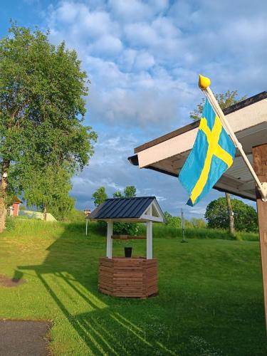 a swiss flag flying next to a gazebo at Ferienhaus Schweden - Hus Else in Gällstad