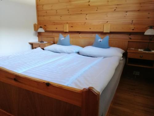 1 dormitorio con 1 cama grande y 2 almohadas azules en Gästehaus Holzfeind, en Hermagor