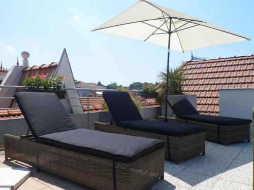 two chairs and an umbrella on a roof at Residhome Arcachon Plazza in Arcachon