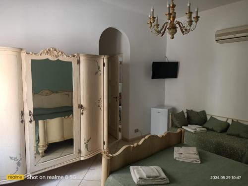a living room with a green couch and a mirror at Bed and Breakfast Almaran in Trapani
