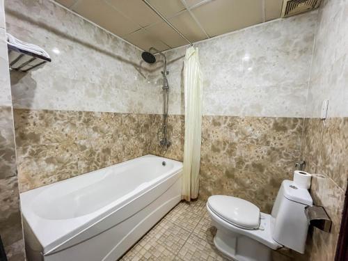 a bathroom with a tub and a toilet and a sink at Quoc Cuong Hotel & Apartment Danang by Haviland in Da Nang