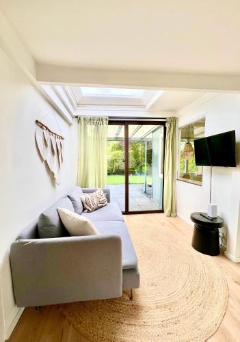a living room with a couch and a television at Cozy family house with spacious garden in the nature near Amsterdam in Vijfhuizen