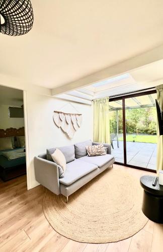a living room with a couch and a large window at Cozy family house with spacious garden in the nature near Amsterdam in Vijfhuizen