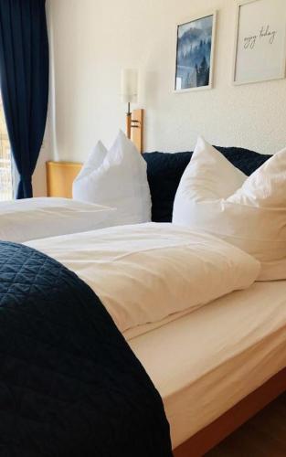 1 Schlafzimmer mit 2 Betten mit weißer Bettwäsche und Kissen in der Unterkunft Am Landhaus - Gästezimmer in Walsheim