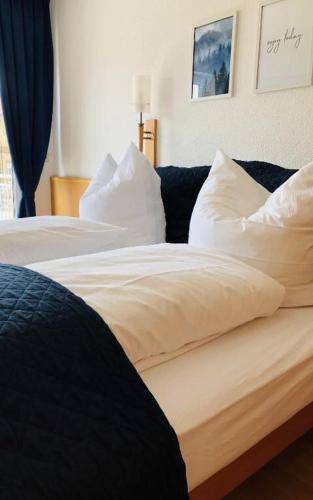 a bedroom with two beds with white sheets and pillows at Am Landhaus - Gästezimmer in Walsheim