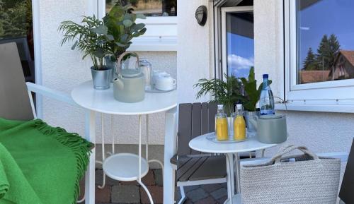 zwei Tische auf einem Balkon mit Pflanzen darauf in der Unterkunft Am Landhaus - Gästezimmer in Walsheim