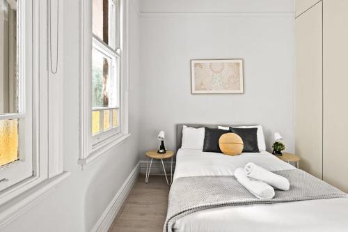 ein weißes Schlafzimmer mit einem Bett mit zwei Kissen in der Unterkunft Lovely Double Room - Nearby Transport & Shops - Shared Bathroom in Killara