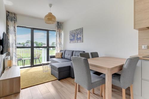 a kitchen and living room with a table and a couch at GRANO FLATS - Sobieszewo - Baltic Porto in Gdańsk