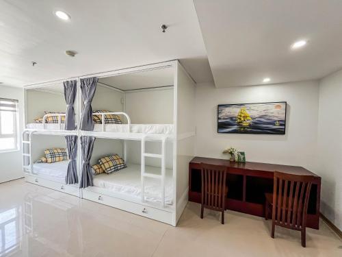 a room with two bunk beds and a desk at Quoc Cuong Hotel & Apartment Danang by Haviland in Da Nang