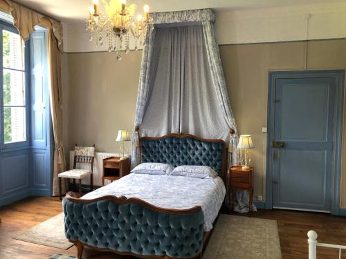 a bedroom with a blue bed with a canopy at Chateau Morinerie in Villiers