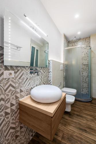 a bathroom with a large white tub and a toilet at Onda Marina Suites in Cagliari