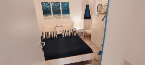 um pequeno quarto com uma cama e uma cadeira em La casa Rosa em Ponza