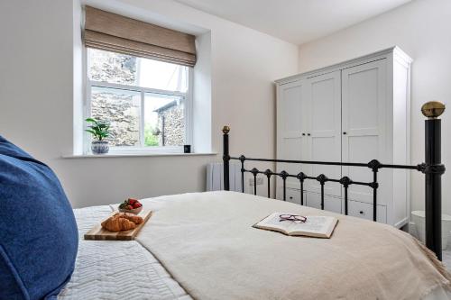 a bedroom with a bed with a bowl of fruit on it at Finest Retreats - Courtyard Cottage in Kendal