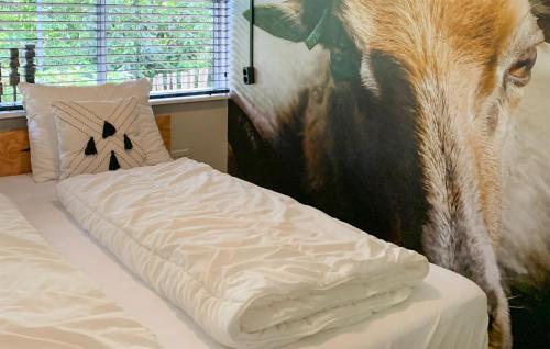 a cow standing next to a bed in a bedroom at Stunning Home In Rheezerveen With Sauna in Rheezerveen