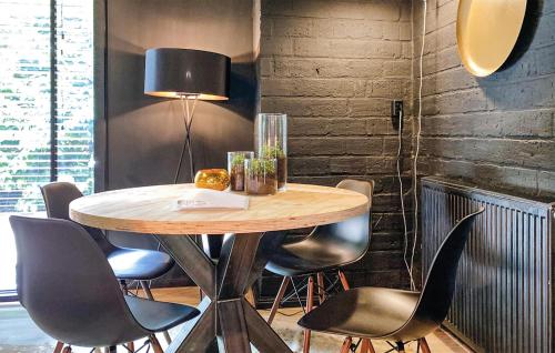 a table in a room with chairs and a lamp at Nice Home In Rheezerveen With Sauna in Rheezerveen