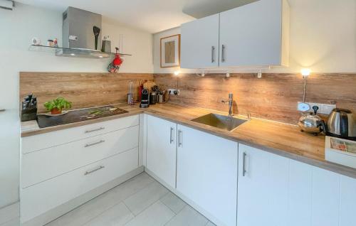 a kitchen with white cabinets and a wooden counter top at Amazing Ship In Winsum With Wifi in Winsum