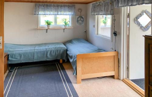 um pequeno quarto com uma cama e duas janelas em Beautiful Home In Grnna With Kitchen em Gränna