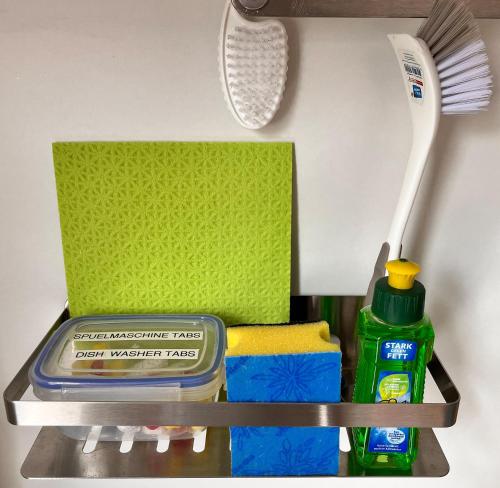 a shelf with a toothbrush and some cleaning products at Apartment am Schloss-Park Wiesbaden Biebrich am Rhein in Wiesbaden