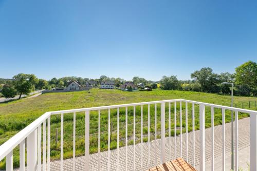 a white deck with a view of a field at GRANO FLATS - Sobieszewo - Baltic Porto in Gdańsk