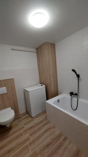 a bathroom with a tub and a toilet and a sink at Gyulai idill apartman in Gyula