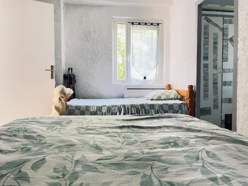 une chambre avec deux lits et une fenêtre dans l'établissement Apt 4-6pers-piscine-parc arboré, à Fitou