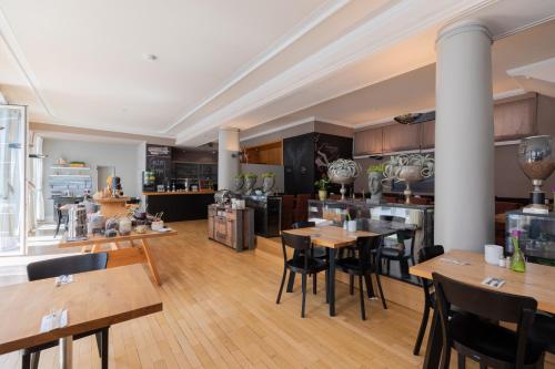 a large kitchen with wooden tables and chairs at Select Hotel Friedrichshafen in Friedrichshafen