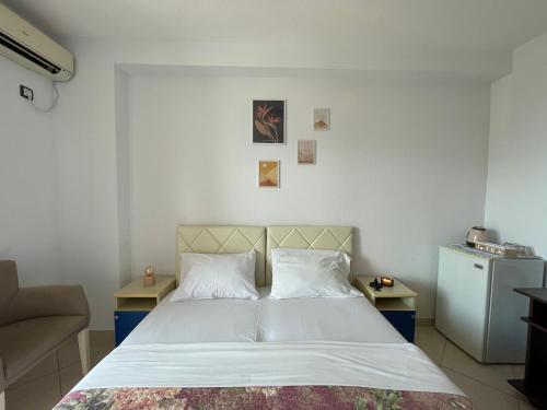 1 dormitorio con 1 cama, 2 mesas y nevera en Villa Ivanovic, en Budva
