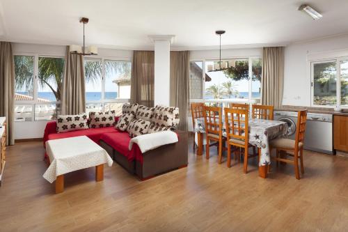 リンコン・デ・ラ・ビクトリアにあるApartamento Bellamarのソファとテーブルと椅子のあるリビングルーム