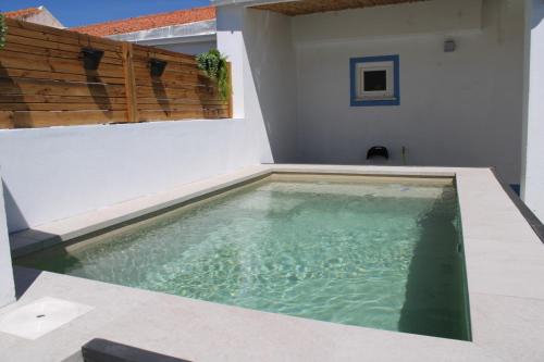 a swimming pool in the side of a house at Azinheira Villa - Grândola in Azinheira dos Barros