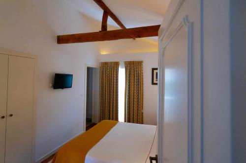 a bedroom with a bed and a tv on the wall at Quinta da Pousada Casa de Campo in Santa Marta de Penaguião
