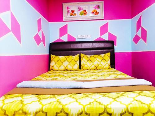 a bedroom with a yellow bed in a pink room at DE GLORY HOTEL UsJ 21 in Subang Jaya