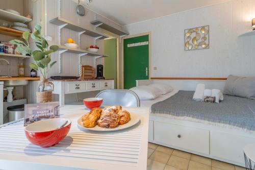 Cette chambre comprend un lit et une table avec une assiette de nourriture. dans l'établissement Le Barclay - Studio proche de la plage, à La Teste-de-Buch