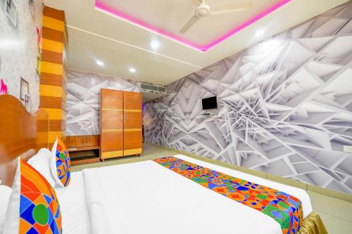 ルディヤーナーにあるFabHotel The Mirageの白いベッドと壁が備わるベッドルーム1室が備わります。