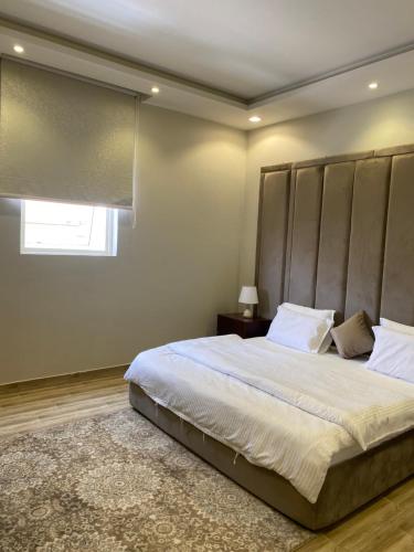 a bedroom with a large bed with a large headboard at أجنحة دارك للشقق الفندقية in Ad Dawādimī