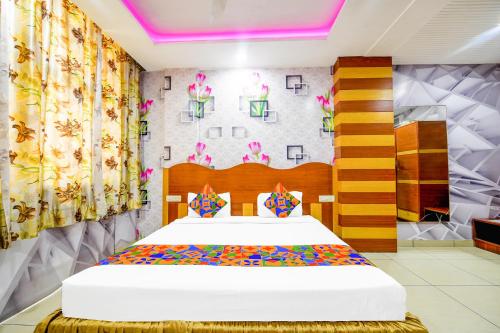 1 dormitorio con 1 cama y una pared con flores en FabHotel Prime The Mirage en Ludhiana