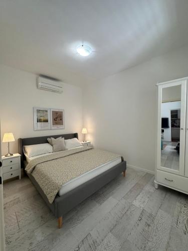 Habitación blanca con cama y espejo en Beach House Mokalo en Orebić
