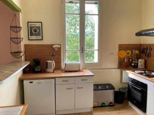 a kitchen with white cabinets and a window at Casa Bauxells in Sahorre