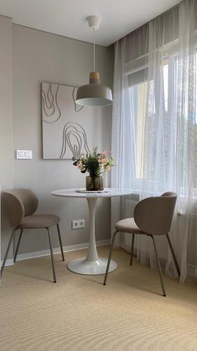 a dining room with a table and two chairs at Amber Shore Apartment in Liepāja