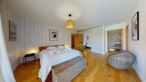 une chambre avec un lit et une chaise dans l'établissement Villa avec clim et piscine chauffée Arès Cap Ferret, à Arès