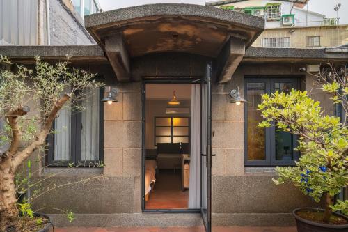 基隆的住宿－安樓文旅Enzo House，通往树木繁茂的房子的敞开的门