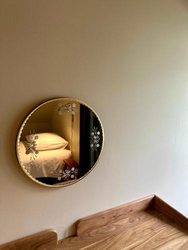 a mirror on a wall with a bed in a room at Gîte Le Four à Pain 6 personnes sur le domaine du Manoir du Rigouneix in Saint-Angel