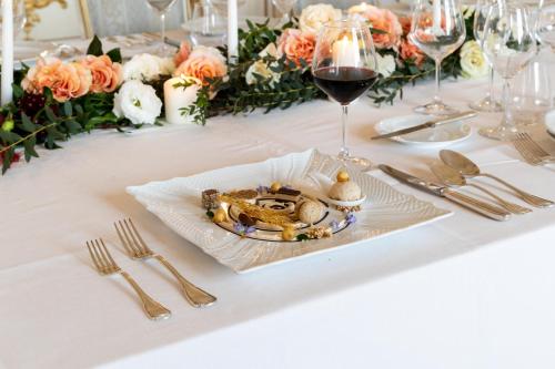 a table with a plate of food and a glass of wine at Relais La Corte dei Papi in Cortona