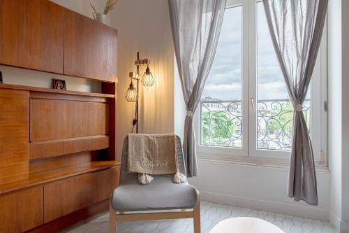 une chaise dans une chambre avec fenêtre dans l'établissement Lucia - Appt sur l'Île Feydeau au cœur de Nantes, à Nantes