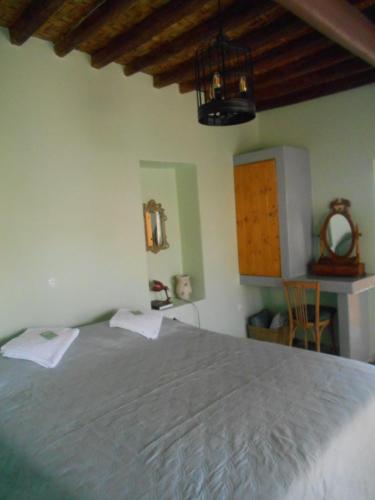 a bedroom with a large bed in a room at MYRTIA , Traditional Kimolos house in Kimolos