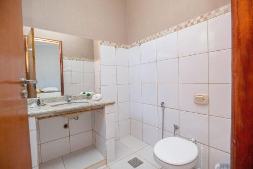 ein Badezimmer mit Toilette, Waschbecken und Spiegel in der Unterkunft Refúgio de Lazer: Chácara c/ Espaço e Conforto in Caldas Novas
