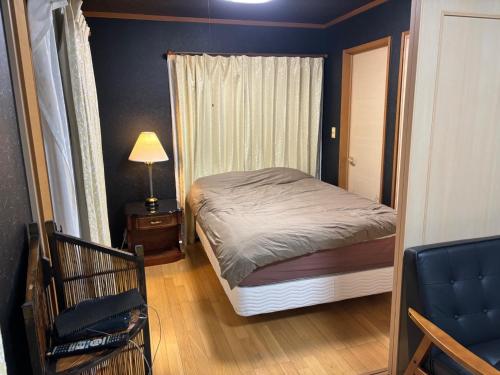 a small bedroom with a bed and a window at Hamachidesu - Vacation STAY 15817 in Akiruno