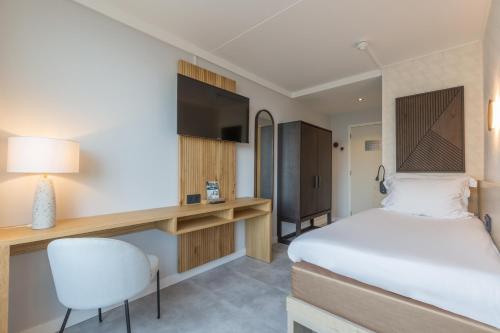 a hotel room with a bed and a desk at Hotel de Baak Seaside in Noordwijk aan Zee