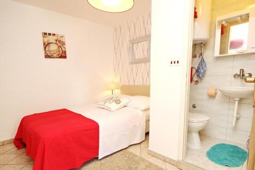 a small bedroom with a bed and a toilet at Room Rose in Baška