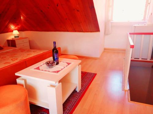 ドゥブロヴニクにあるOld town Jelena loft Roomのベッド1台、テーブル(ワイン1本付)