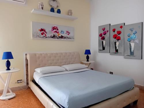 a bed in a bedroom with paintings on the wall at BBX Palermo Centro in Palermo